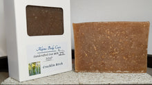 Load image into Gallery viewer, Bar of Cracklin' Birch soap next to its packaging on a stone surface.